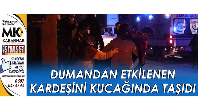 Dumandan etkilenen kardeşini kucağında taşıdı