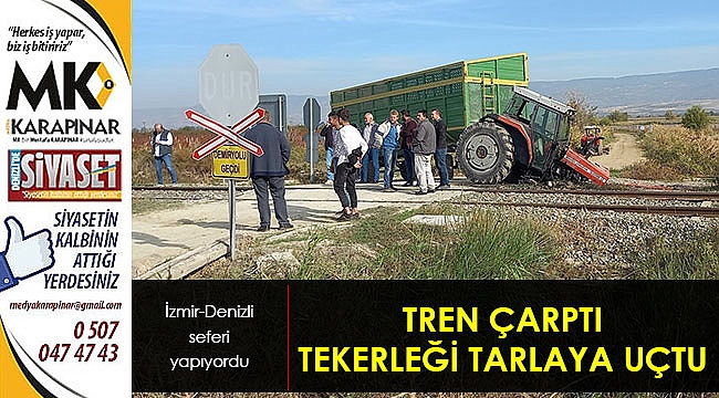 Trenın çarptığı traktörün tekeri tarlaya uçtu