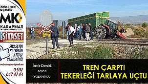 Trenın çarptığı traktörün tekeri tarlaya uçtu